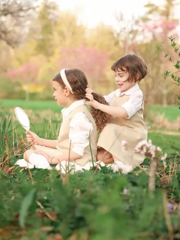Big sister brushing her little sister's hair in a garden, outdoor photography by Photoholic, Rockland County NY