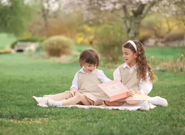 Brother and sister on a picnic blanket opening a gift, outdoor photography by Photoholic, Rockland County NY
